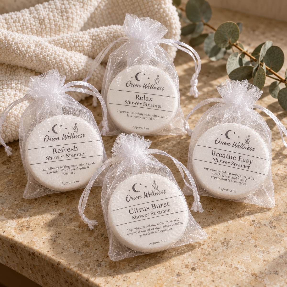 Orion Wellness four shower steamer scents on a bathroom vanity