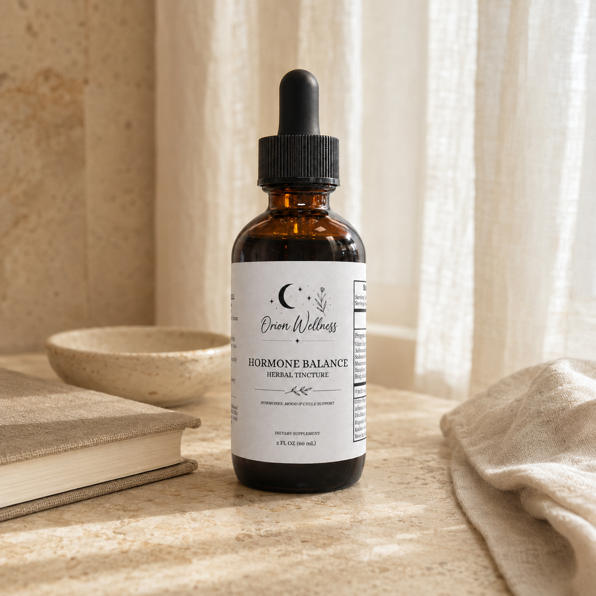 Orion Wellness Hormone Balance tincture on a pale stone vanity with neutral linen, a closed journal, and a small ceramic dish.